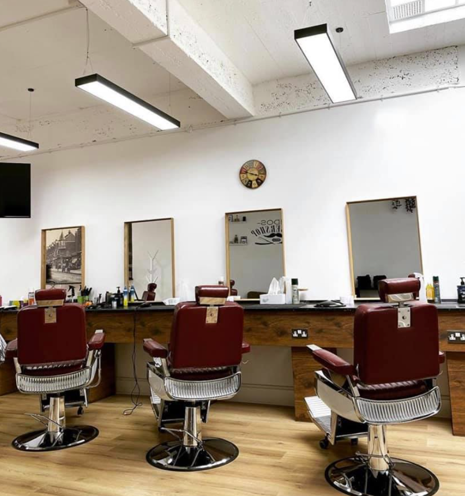 Three red barber chairs lined up at MIDOS